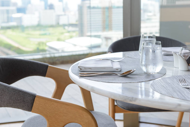 Establecimiento de mesa en el restaurante. Mesa elegante decorada, vasos, servilleta, cuchillo, tenedor y cuchara
 - Foto, imagen