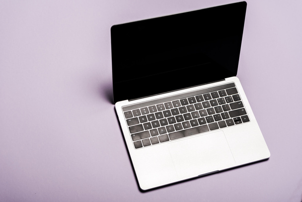overhead view of modern laptop with blank screen on purple  - Foto, imagen