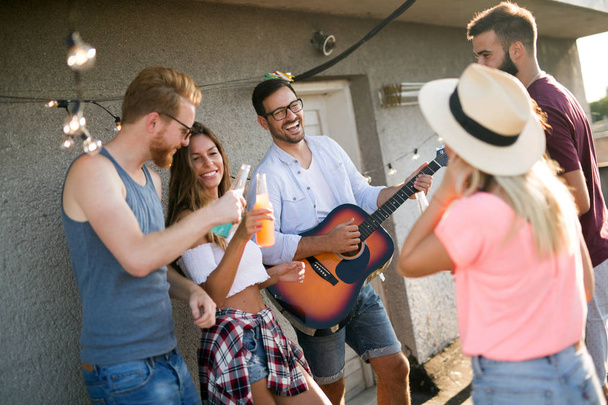 Group of happy friends having party and fun on rooftop - Photo, image