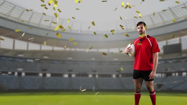 Animation of a Caucasian male rugby player holding a ball and looking to camera with golden confetti falling and a sports stadium in the background - Záběry, video