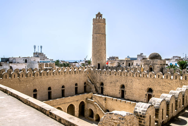 Wieża Ribat Sousse, górujący nad jego kamiennymi ścianami na tle portu i morza. Tunezja. Afryka Północna. - Zdjęcie, obraz