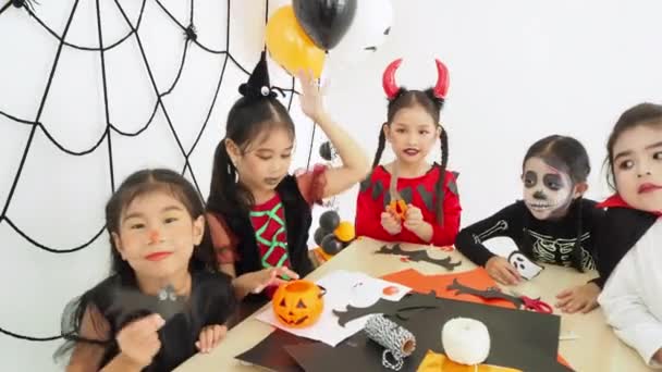 Seskupit malou asijskou dívku do Halloweenské maškarní oslavovat prázdniny na Halloweenské párty v pokoji - Záběry, video