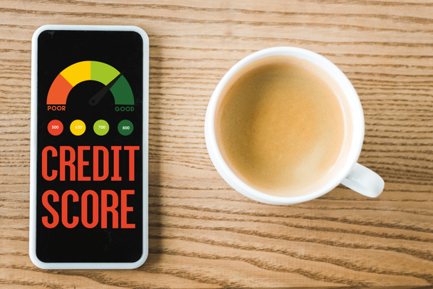 top view of smartphone with credit score lettering on screen near cup of coffee on table  - Φωτογραφία, εικόνα