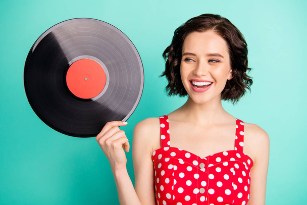 Photo of nice cute encouraged cheerful girlfriend thinking on where she can listen to music recorded in this plate while isolated with teal background - Foto, Imagen