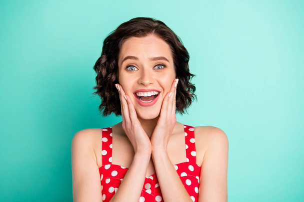 Photo of cheerful astonished beautiful gorgeous woman taking breath because of having been positively scared while isolated with teal background - Foto, imagen