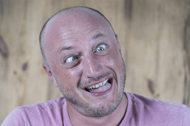Handsome caucasian bald man making funny face, close up - 写真・画像