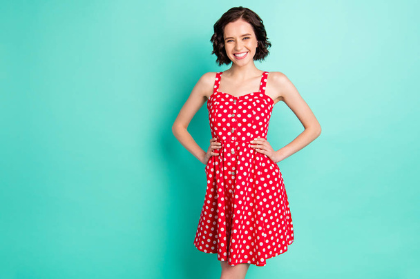 Photo of brightly smiling cute nice fascinating girlfriend wearing vivid red dress while isolated with teal background - Foto, Imagem