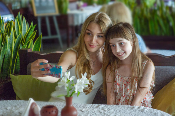 Chica tomando una selfie con su madre o hermana
 - Foto, Imagen