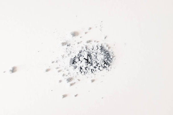Closeup shot of gray sandy powder on a white background - Foto, afbeelding
