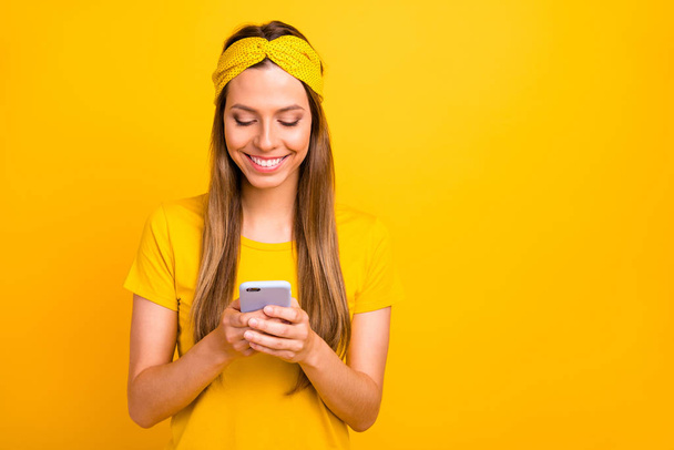 Closeup photo of pretty lady holding telephone hands wear casual t-shirt isolated yellow background - Valokuva, kuva
