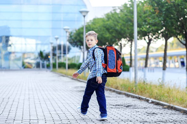 El chico va a la escuela con una mochila. El concepto de infancia, educación y escuela
 - Foto, imagen