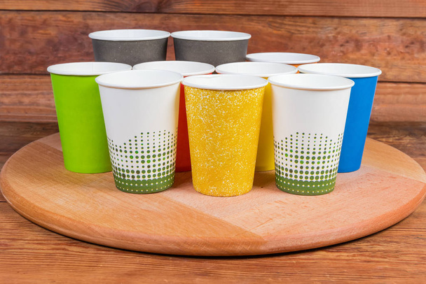 Différentes tasses en papier jetables sur le plateau de service en bois
 - Photo, image