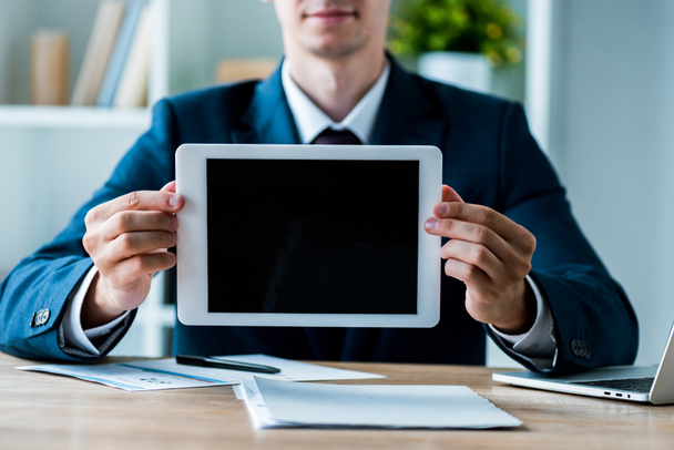 selective focus of happy man holding digital tablet with blank screen in office  - Foto, afbeelding