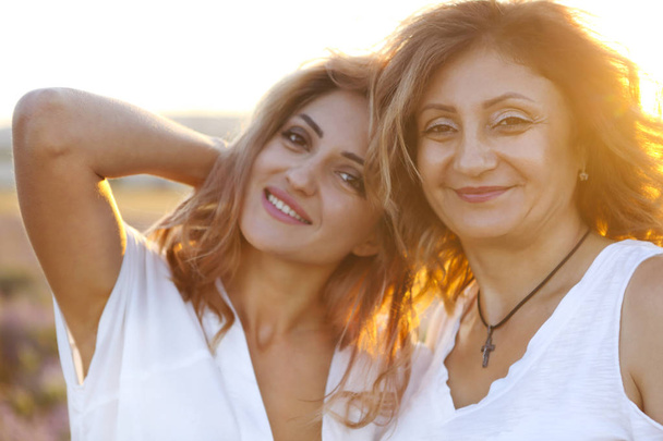 Middle age woman with her adult daughter in sunset light - Photo, Image