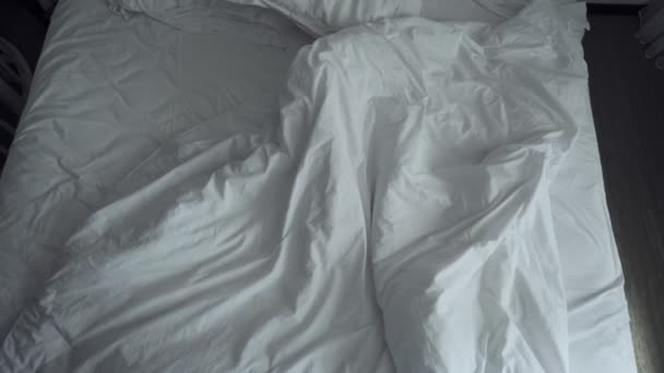 Ακατάστατα τσαλακωμένα κρεβάτια με λευκά ρούχα. - Πλάνα, βίντεο