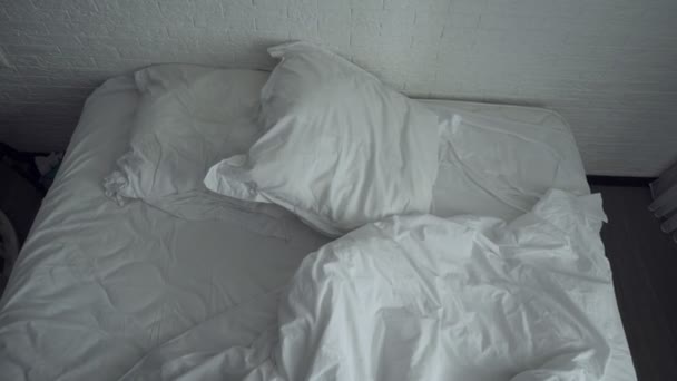 白い寝具付きの乱雑なくしゃくしゃのベッド. - 映像、動画