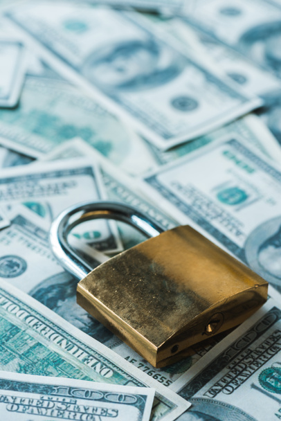 close up of safety padlock on dollar banknotes  - 写真・画像