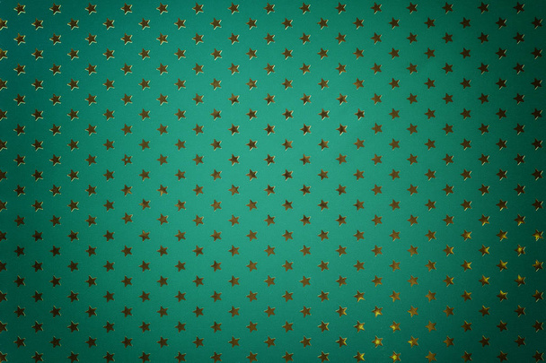 Fond vert foncé de papier d'aluminium métallique avec un motif d'étoiles dorées avec vignette
. - Photo, image