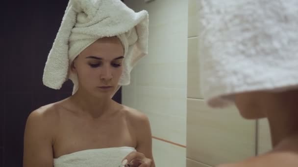 Mujer joven aplicando crema base después de la ducha de la mañana
. - Metraje, vídeo
