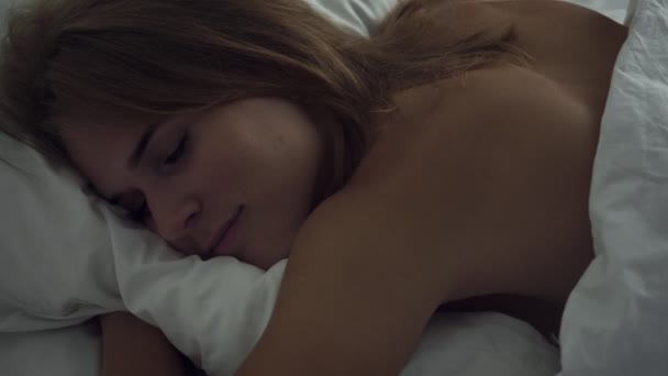 Mujer joven durmiendo en una acogedora cama en el dormitorio
. - Imágenes, Vídeo