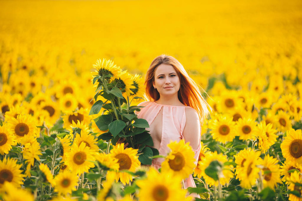 Hermosa chica en un enorme campo amarillo de girasoles
.  - Foto, Imagen