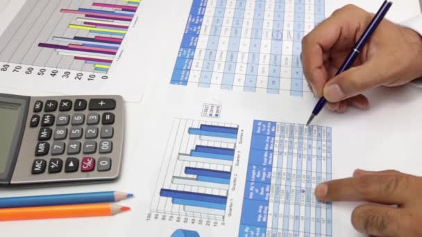 business, people, paperwork, office and technology concept - businessman hands with calculator and pen writing and filing papers on table. Examining business graph and Finance management - Footage, Video