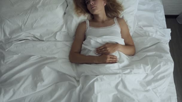 Woman awakening in comfortable cozy bed stretching and gets up. - Felvétel, videó