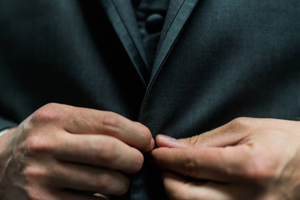 Closeup of a man buttoning his classic suit jacket - Foto, afbeelding