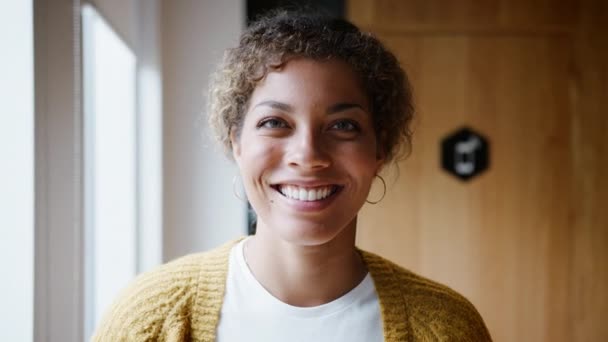 Young mixed race woman standing by the window in an office laughing, head and shoulders, close up - Filmmaterial, Video