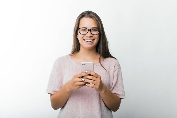 Portrait of charming young woman holding smartphone and looking at the camera, Blogger ready to post an article  - Photo, Image