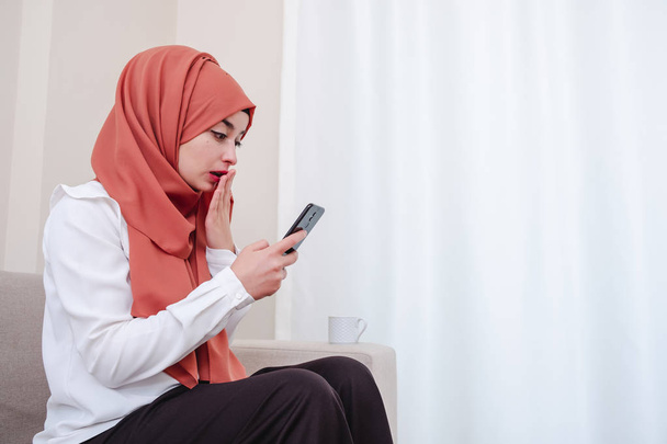 Ragazza musulmana utilizzare smart phone e lei scioccato, ragazza è preso alla sprovvista o sorpreso
 - Foto, immagini