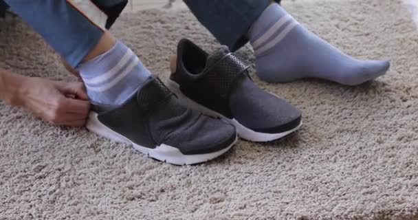 Persoon die sneakers op zacht tapijt zet - Video