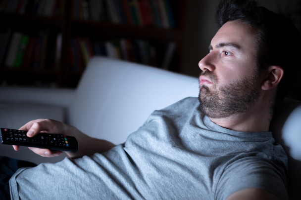 Ленивый человек смотрит телевизор ночью в одиночестве
 - Фото, изображение