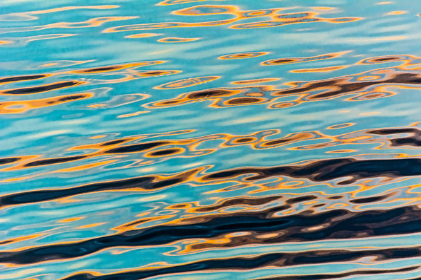 reflexión en ondulaciones de agua
 - Foto, imagen