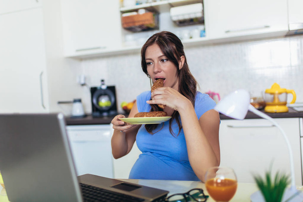 Mulher grávida com barriga trabalhando como freelancer com laptop
 - Foto, Imagem
