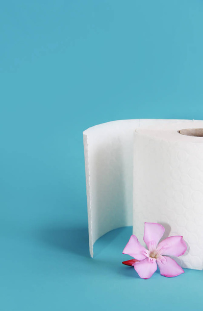 white toilet paper roll with flowers decor on a blue background - Photo, Image
