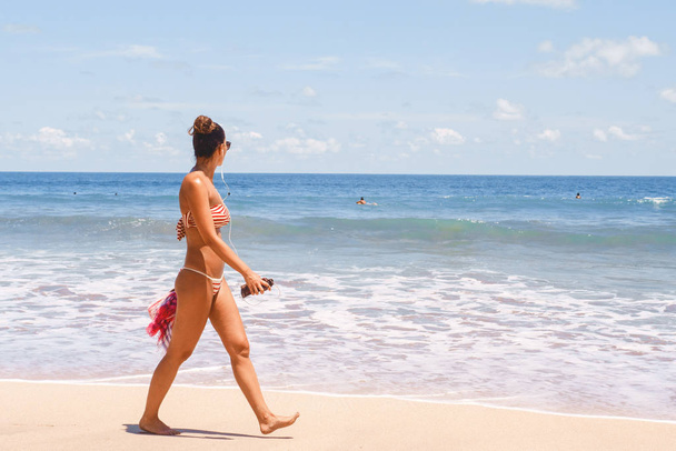 A woman walks along the beach along the sea. - Fotó, kép