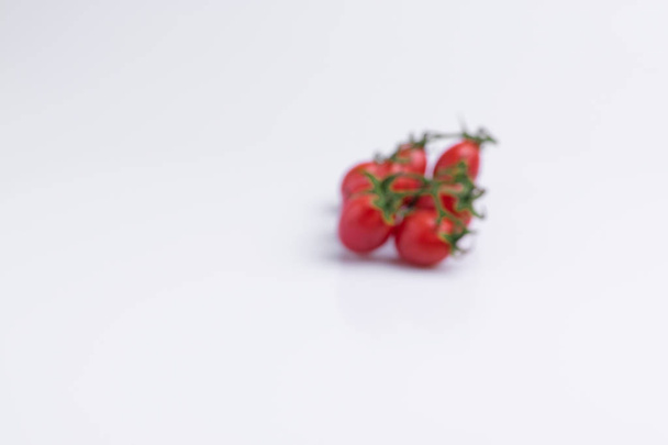 Κλαδί ντομάτας με σταφύλι ή κεράσι. Σωρός από κόκκινες ντομάτες απομονωμένες σε λευκό φόντο - Φωτογραφία, εικόνα