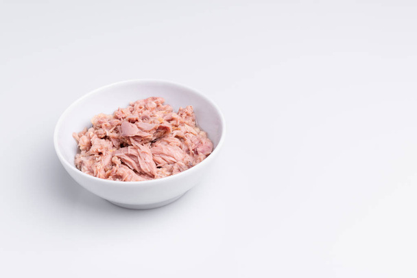 Canned tuna in a white bowl, isolated on white background, angle view - Foto, immagini