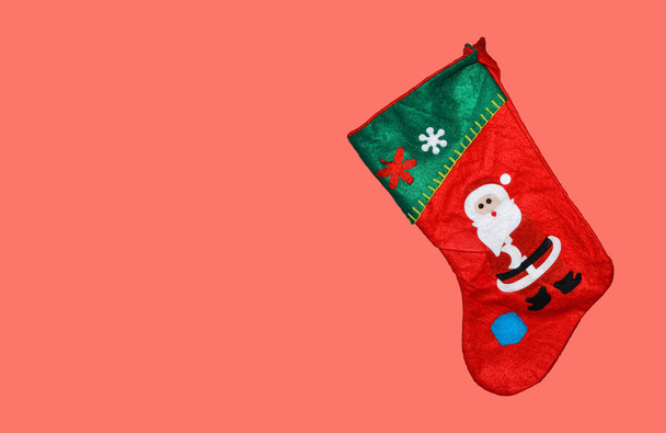 Cute Christmas stocking isolated on pink or coral background. Copy space - Photo, Image