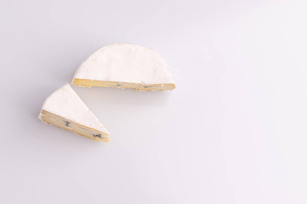 Top view of blue cheese with white surface, isolated on white background. Mix of gorgonzola and camembert / brie cheese - Zdjęcie, obraz