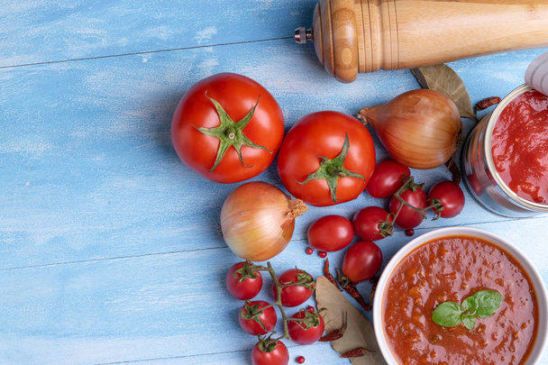 Болонья з томатним соусом у білій тарілці на фоні сільського дерев'яного синього столу
 - Фото, зображення