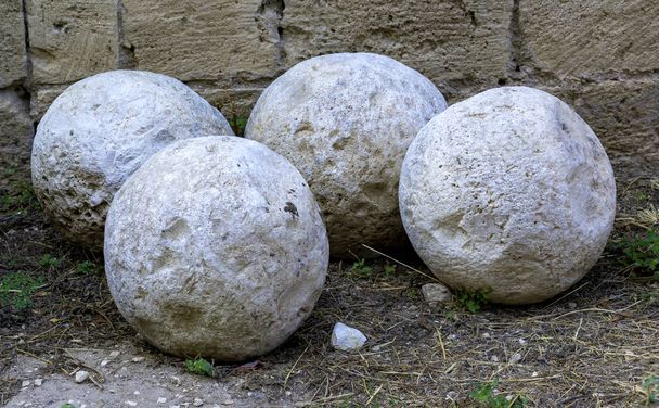 中世の大砲で使用され、城の広場に保存されている古代の石のボールのグループ - 写真・画像