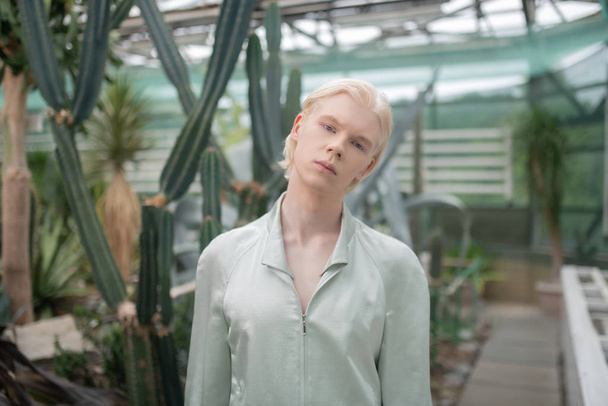 Model standing near cactuses while posing in greenhouse - Foto, afbeelding