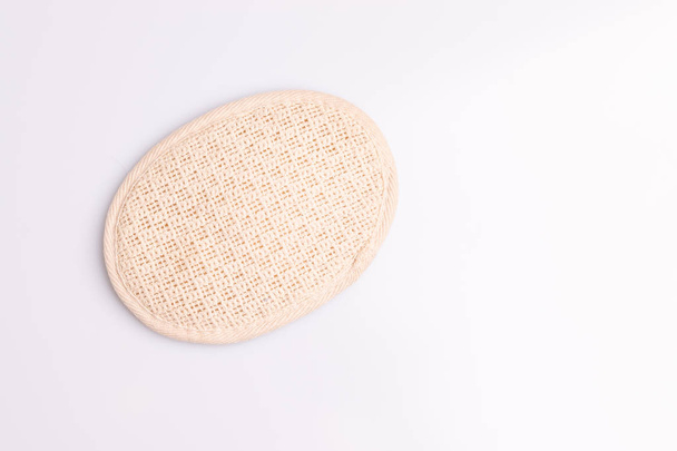 Губка из натурального волокна для очистки тела на белом фоне
 - Фото, изображение