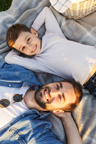 Junger Mann amüsiert sich mit seinem kleinen Bruder oder Sohn im Park. - Foto, Bild