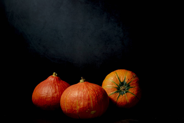 Three Pumpkins in black background - Foto, imagen