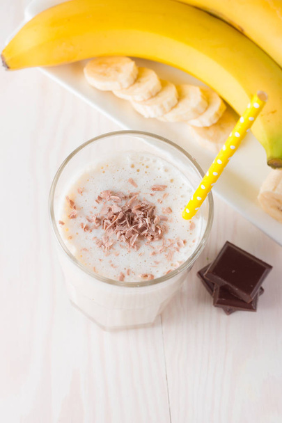 Φρέσκο έκανε σοκολάτα Smoothie μπανάνας σε ένα ξύλινο τραπέζι. Επιλεκτική εστίαση. Milkshake με αμύγδαλα. Πρωτεϊνική δίαιτα. Υγιεινή τροφίμων και ποτών έννοια. - Φωτογραφία, εικόνα