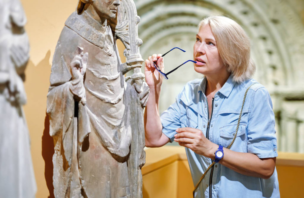 Kobieta odwiedzający patrząc na wystawę w Muzeum starożytnej rzeźby. - Zdjęcie, obraz