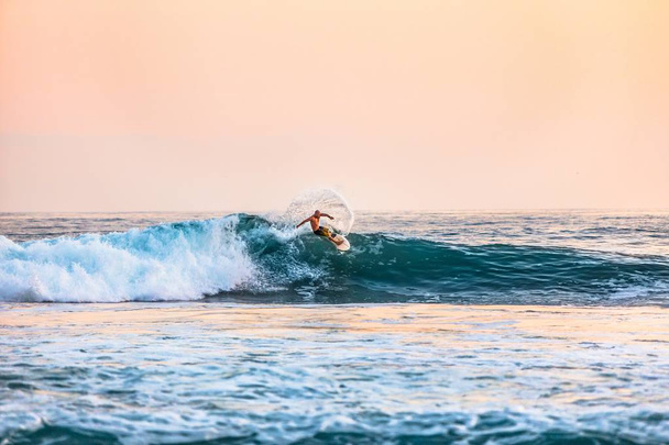 Shot of a male surfing on the sea during daytime - Фото, изображение
